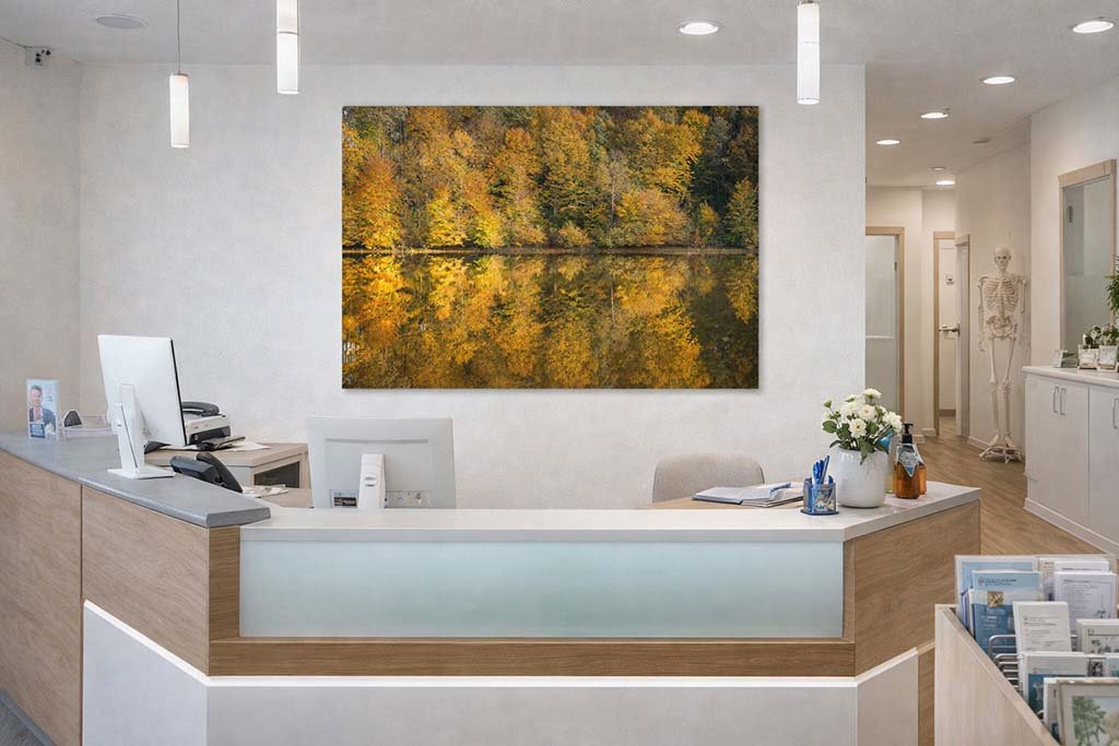 Das Wandbild Herbstspiegel im Empfangsbereich einer Arztpraxis schafft durch seine warmen Farben und die beruhigende Symmetrie eine entspannte Atmosphäre für Patienten.