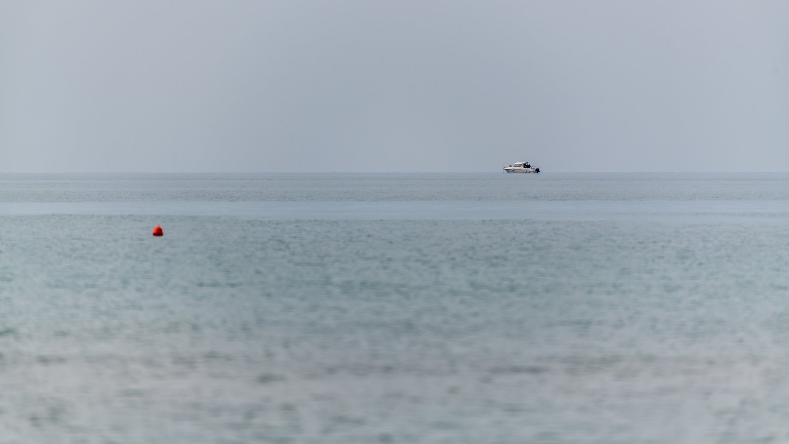 Minimalistisches Wandbild Meer mit Boot, sorgt für optische Weite und Ruhe in Wartezimmern oder Fluren.