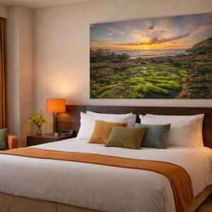 Das Wandbild Sonnenaufgang als stimmungsvolles und warmes Kunstwerk über einem Bett in einem modern eingerichteten Hotelzimmer