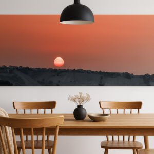 Das Wandbild Sonnenaufgang in den Marken im 2:1 Panorama-Format als stimmungsvolles und farbgewaltiges Kunstwerk an der Wand eines modernen Esszimmers.