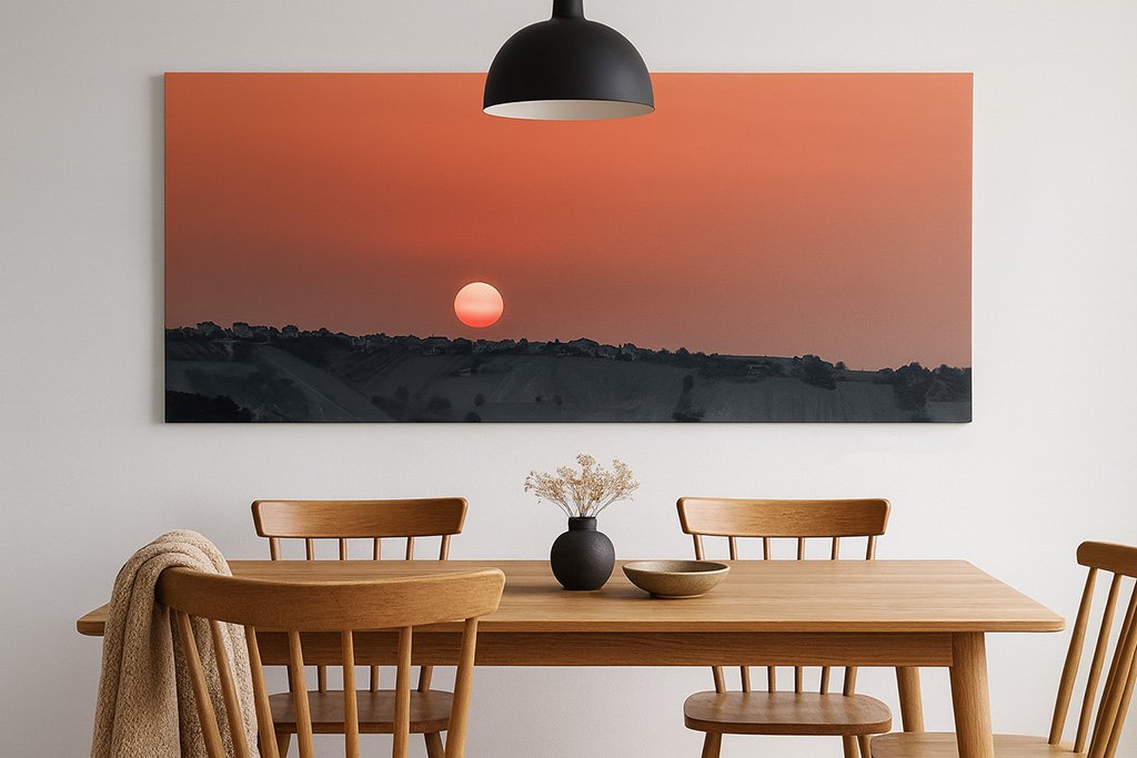 Das Wandbild Sonnenaufgang in den Marken im 2:1 Panorama-Format als stimmungsvolles und farbgewaltiges Kunstwerk an der Wand eines modernen Esszimmers.