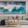 Das Wandbild Türkise Gischt als lebendiger und farbgewaltiger Blickfang über einer Couch in einem modern gestalteten Wohnzimmer