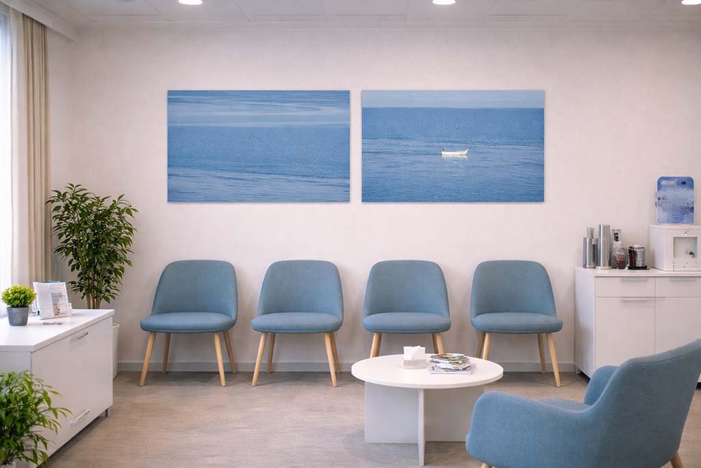Die Wandbilder Weißes Boot und Ganz Blau als harmonisches Set in einem hellen Praxis-Wartezimmer