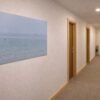 Das minimalistische Wandbild Weites Meer als einladendes Kunstwerk im Flur eines modernen Wohnhauses