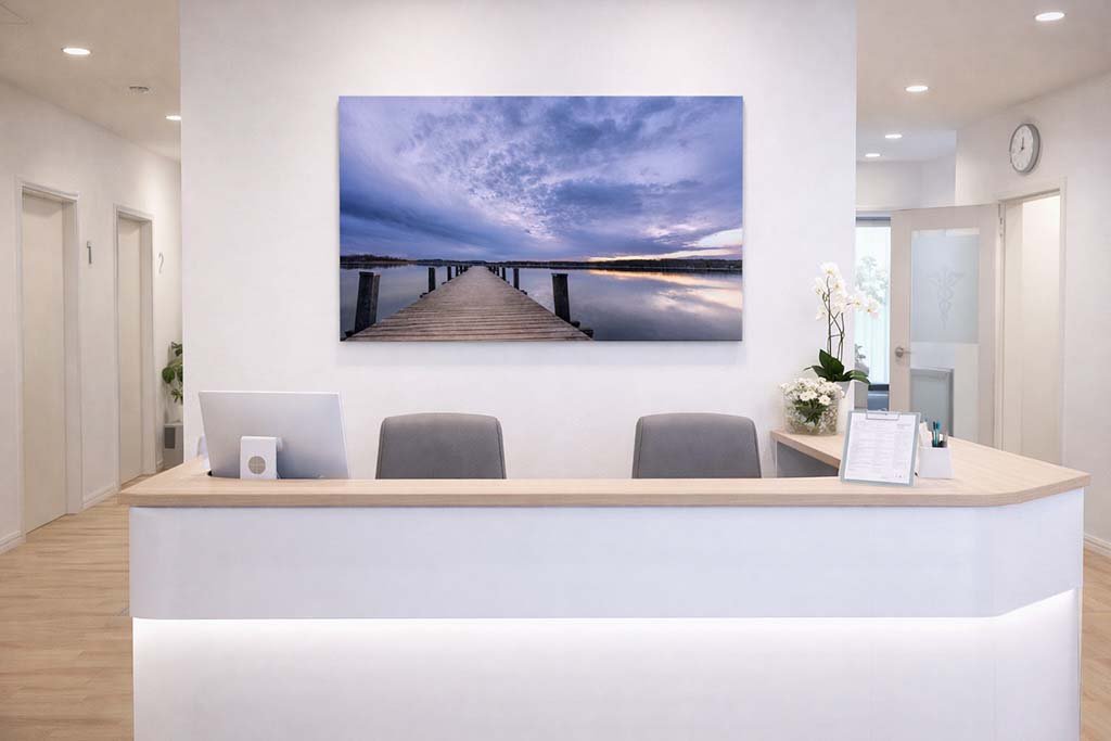 Das Wandbild Wörthsee im 16:9 Panorama-Format als beruhigender und stilvoller Fokuspunkt im Empfangsbereich einer modern gestalteten Arztpraxis.