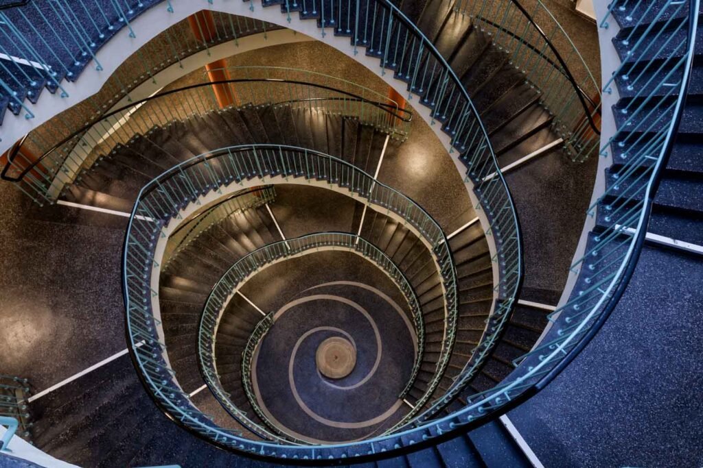 Grafische Architekturaufnahme einer Wendeltreppe aus der Vogelperspektive.